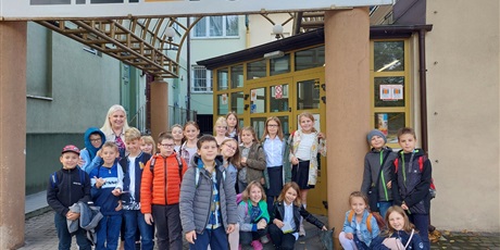 Powiększ grafikę: Wielobarwna fotografia w kształcie prostokąta leżącego przedstawiająca uczniów klasy 3F, którzy wraz z wychowawczynią stoją przed wejściem do Teatru Miniatura.