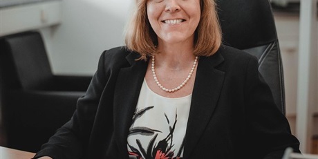 Powiększ grafikę: Barwna fotografia w kształcie prostokąta stojącego przedstawiająca kobietę przy klawiaturze komputerowej.