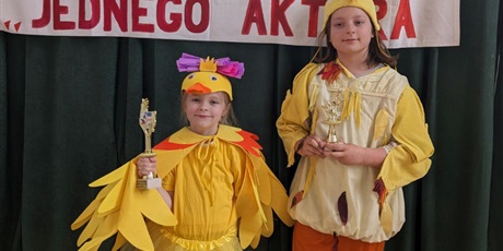 Powiększ grafikę: Wielobarwna fotografia w kształcie prostokąta stojącego przedstawiająca dwoje młodszoszkolnych dzieci w strojach kaczki.