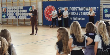 Powiększ grafikę: Barwna fotografia w kształcie prostokąta leżącego przedstawiająca uroczystość rozpoczęcia roku szkolnego.