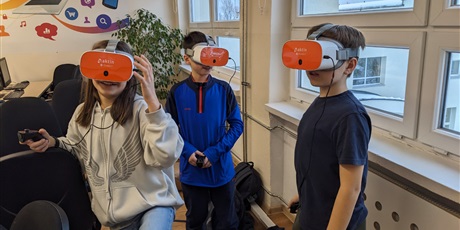 Powiększ grafikę: Wielobarwna fotografia przestawiająca troje uczniów w okularach VR. W tle sala 611.